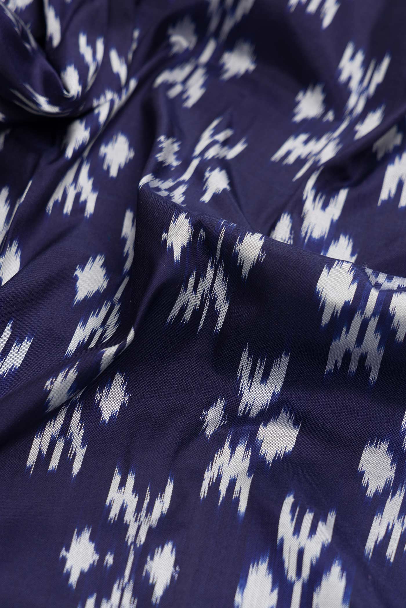 Close up of Navy Blue Dual Tone Double Ikat Saree with Ikat Print on the body and Ikat Border.  displaying folds