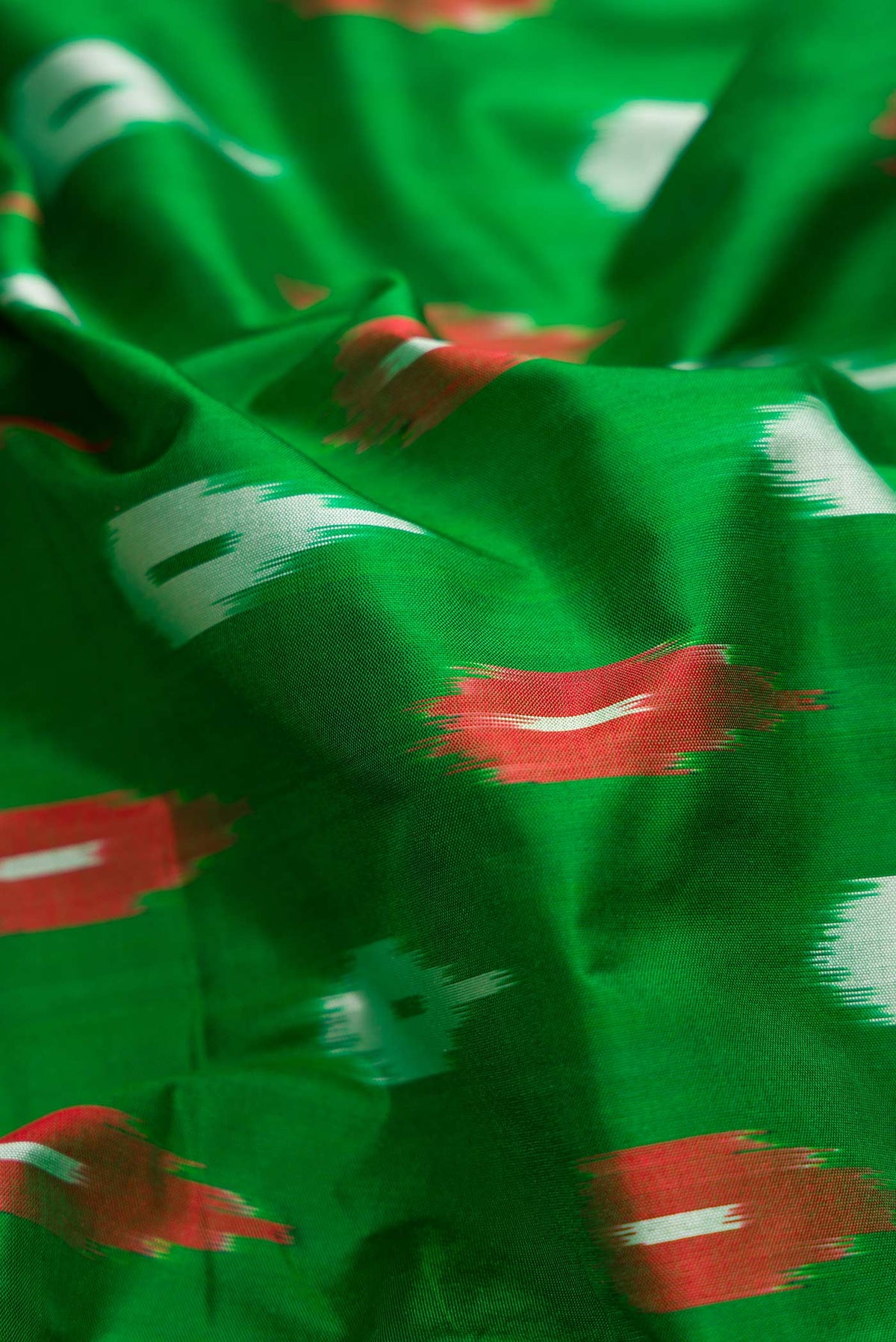 Close up of Green Pochampally Silk Saree with Pure Ikat on the body and Ikat Border displaying folds