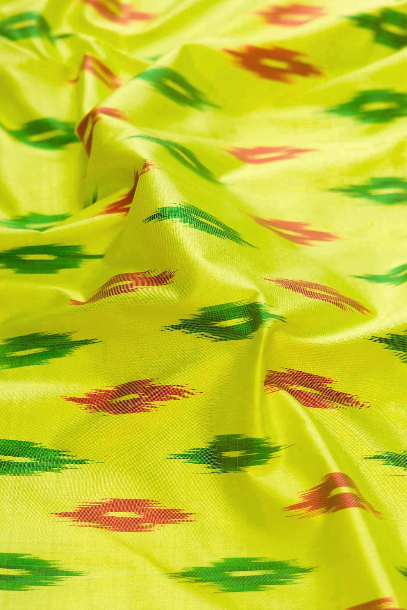 Close up of Parrot Green Dual Tone Double Ikat Saree with Ikat Print on the body and Ikat Border displaying folds