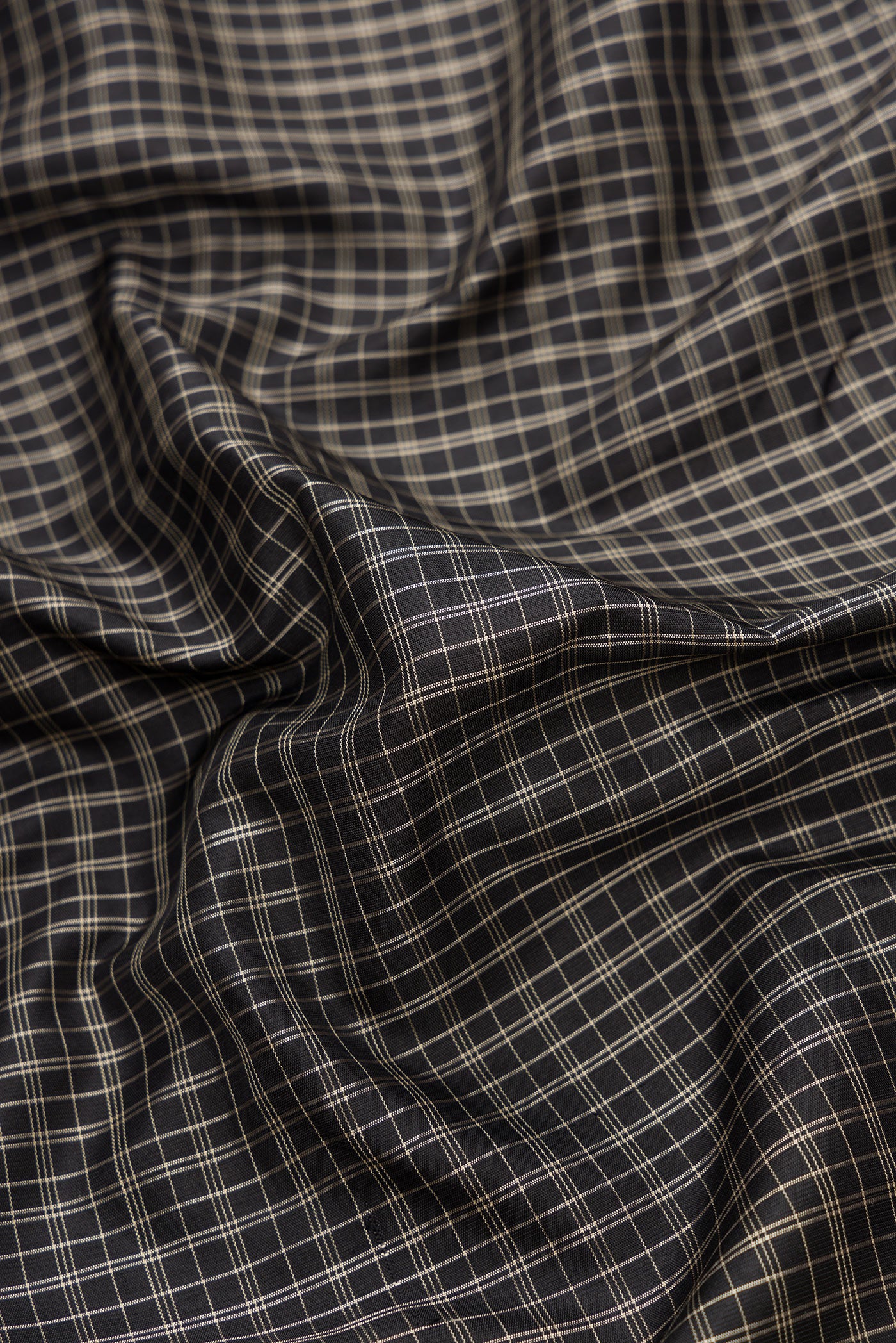 Close up of Black Dual Tone Gadwal Silk Saree with Checked design on the body and Temple Border.  displaying folds