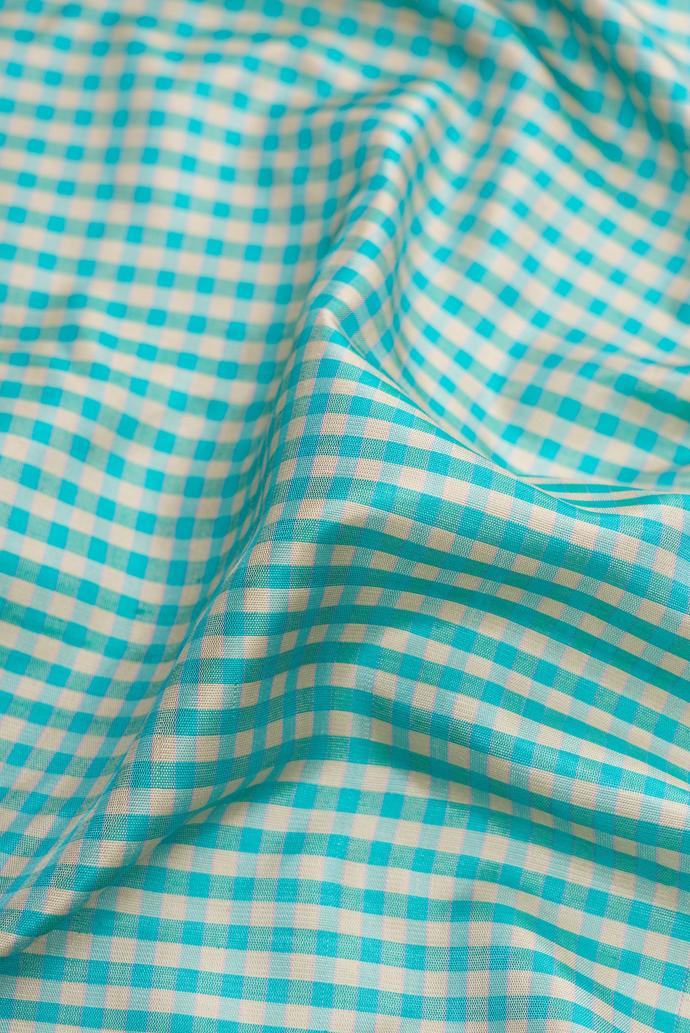 Close up of Light Blue Dual Tone Gadwal Silk Saree with Checked design on the body and Plain Border.  displaying folds