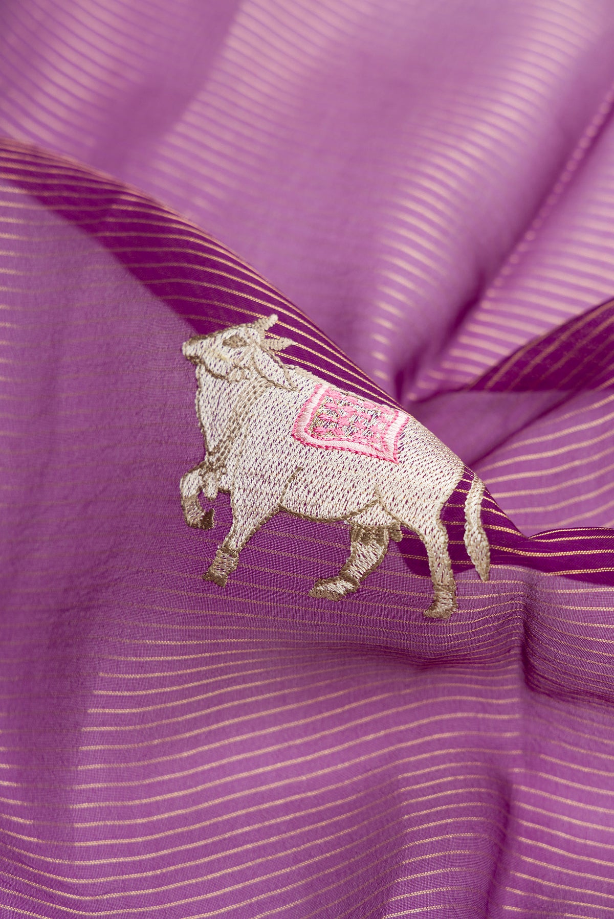 Close up of Purple Dual Tone Organza Silk Saree with Embroidery on the body and Embroidery Border.  displaying folds