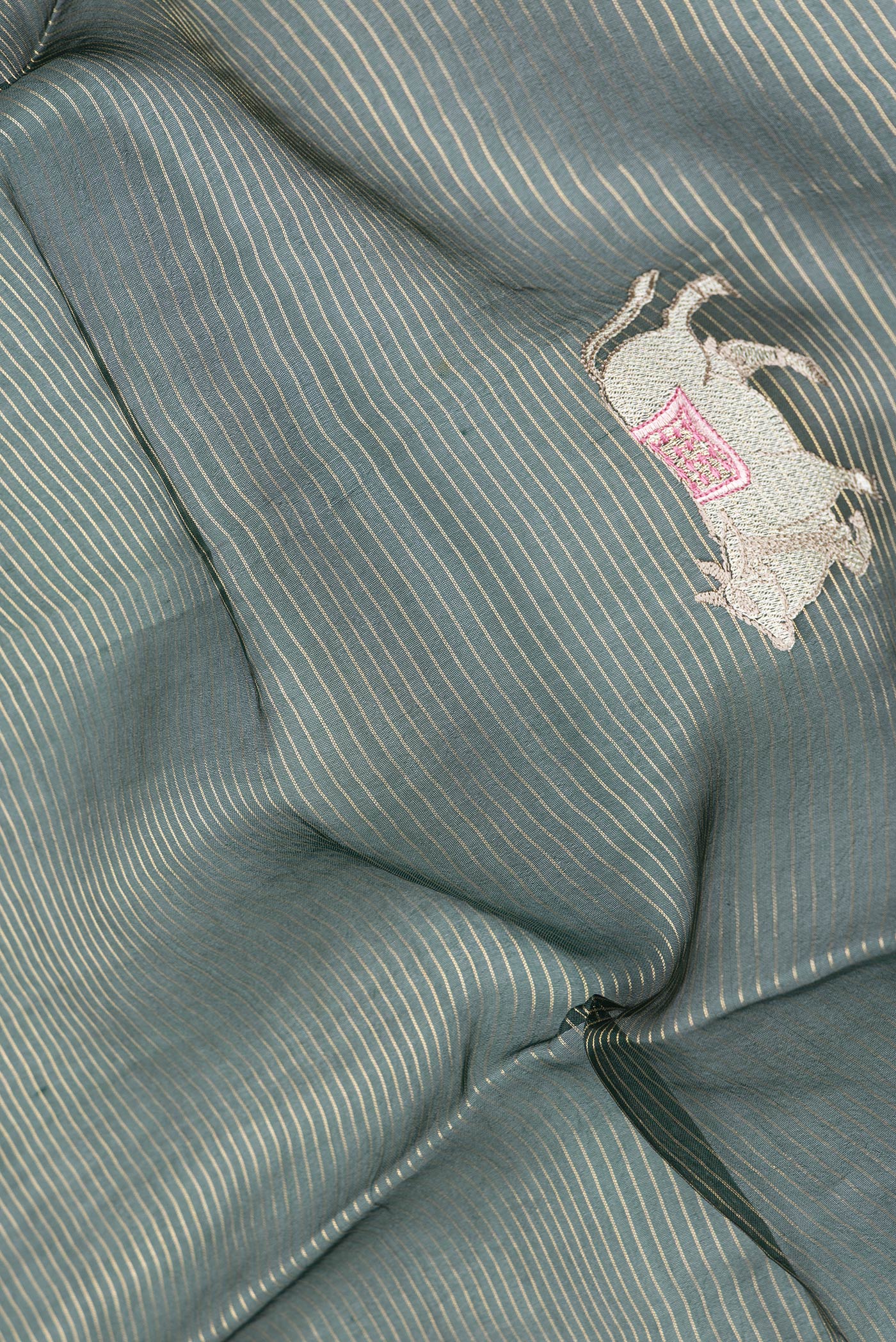 Close up of Bottle Green Dual Tone Organza Silk Saree with Stripes on the body and Fancy Border.  displaying folds