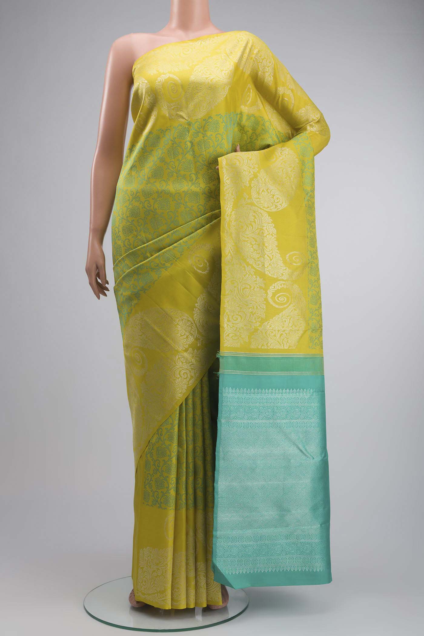 Green Kanchipuram Silk Saree with Jacquard design on the body and Zari Border displayed on a mannequin