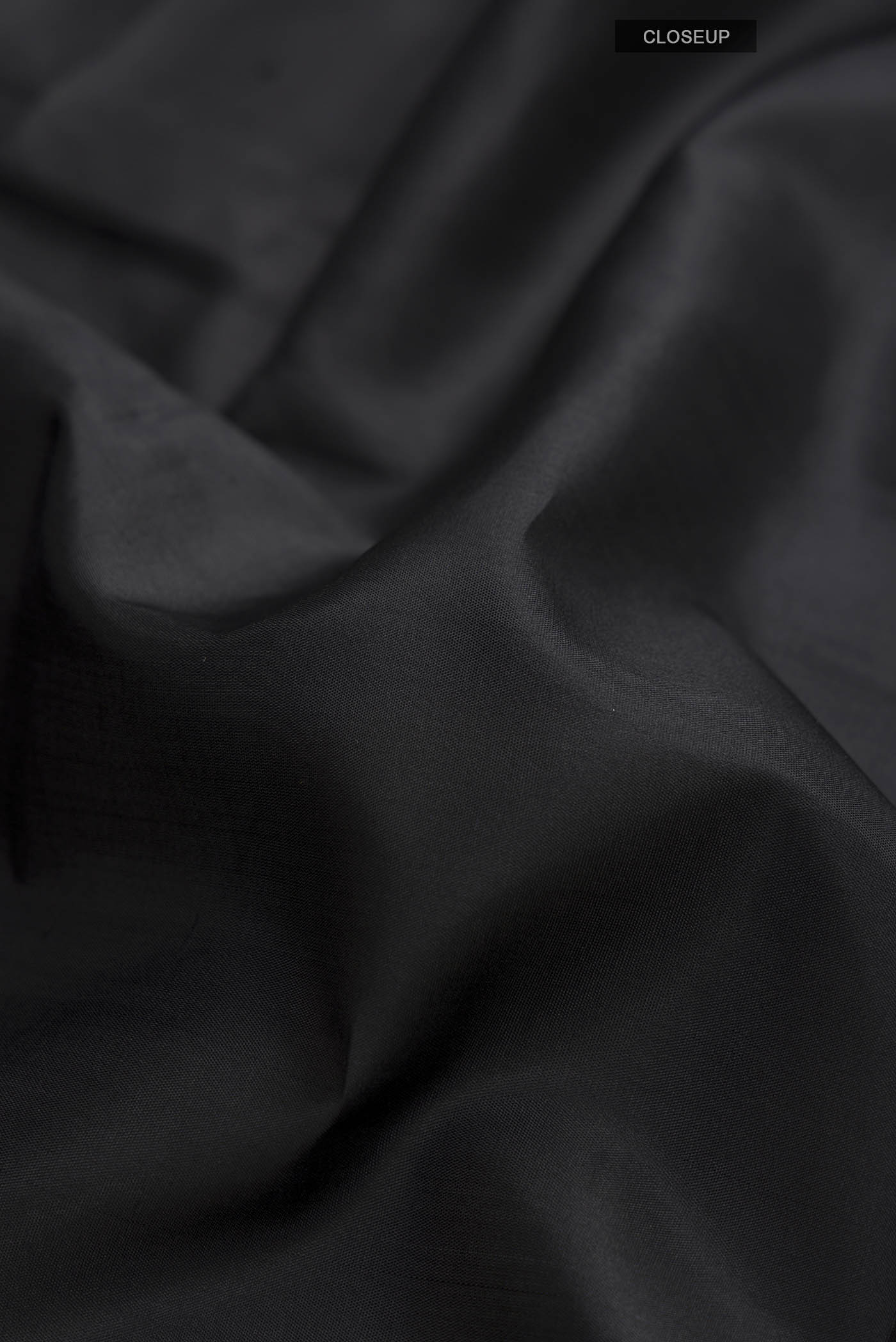 Close up of Black Kanchipuram Silk Saree with Plain Body and Zari Border displaying folds