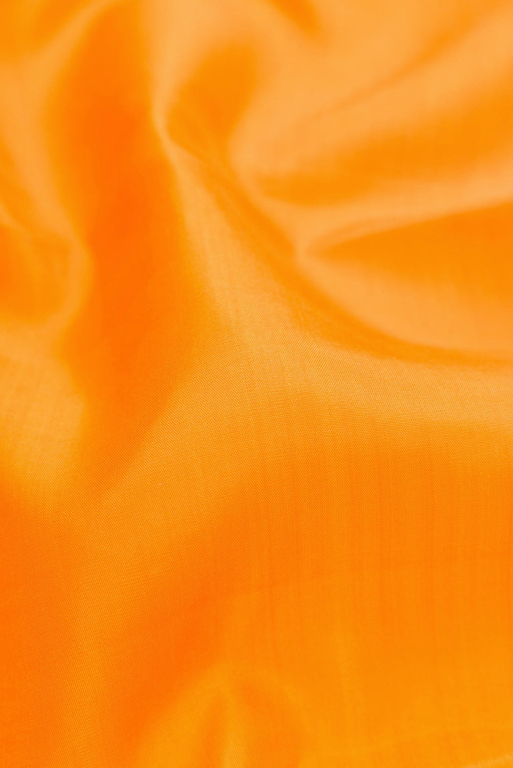 Close up of Orange Dual Tone Kanjivaram Silk Saree with Plain Body and Zari Border.  displaying folds