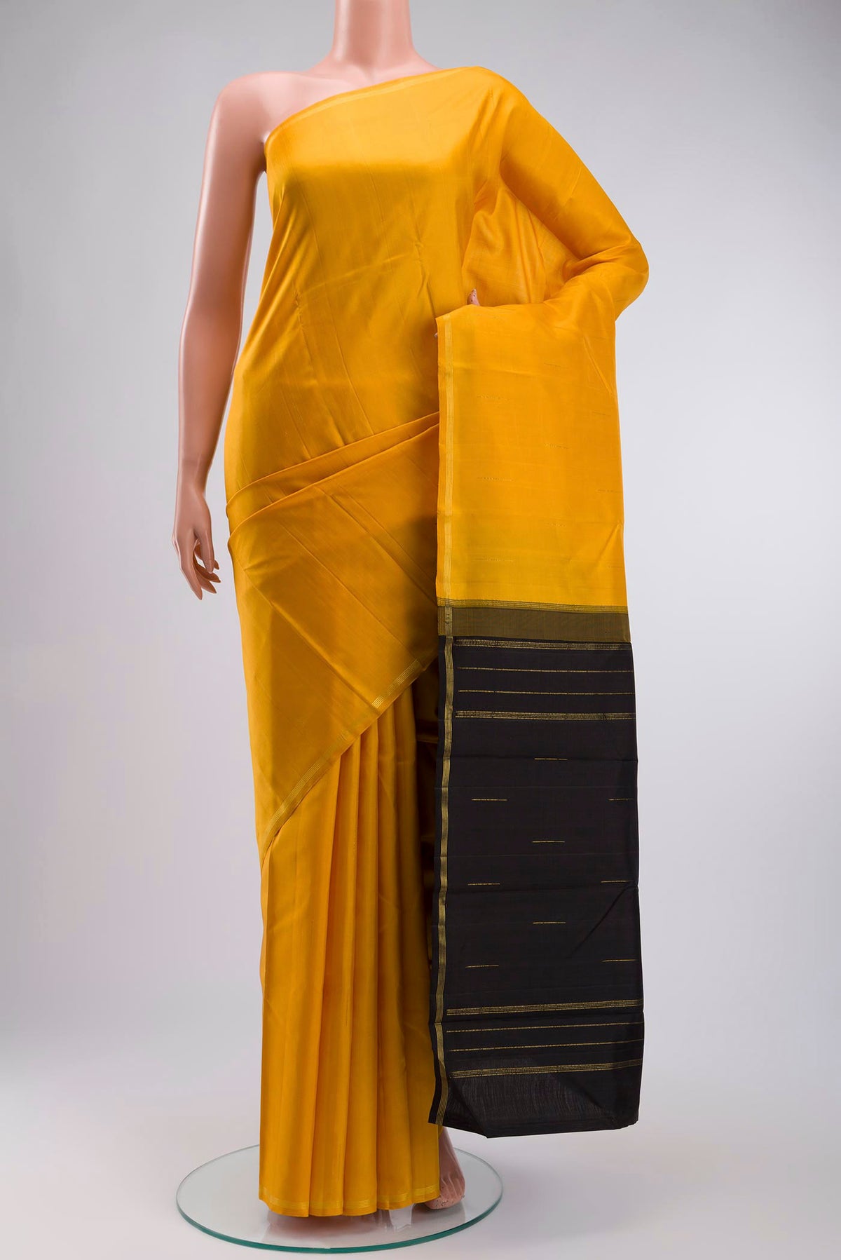 Yellow Kanchipuram Silk Saree with Zari Butta on the body and Zari Border displayed on a mannequin