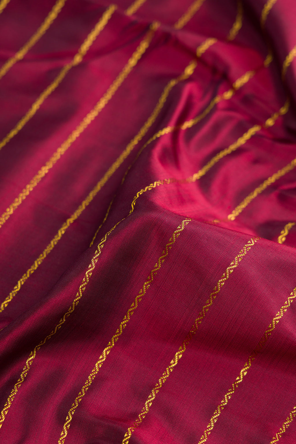 Close up of Pure Silk Pure Zari Maroon Dual Tone Kanchipuram Nine Yards Saree with Stripes on the body and Zari Border.  displaying folds