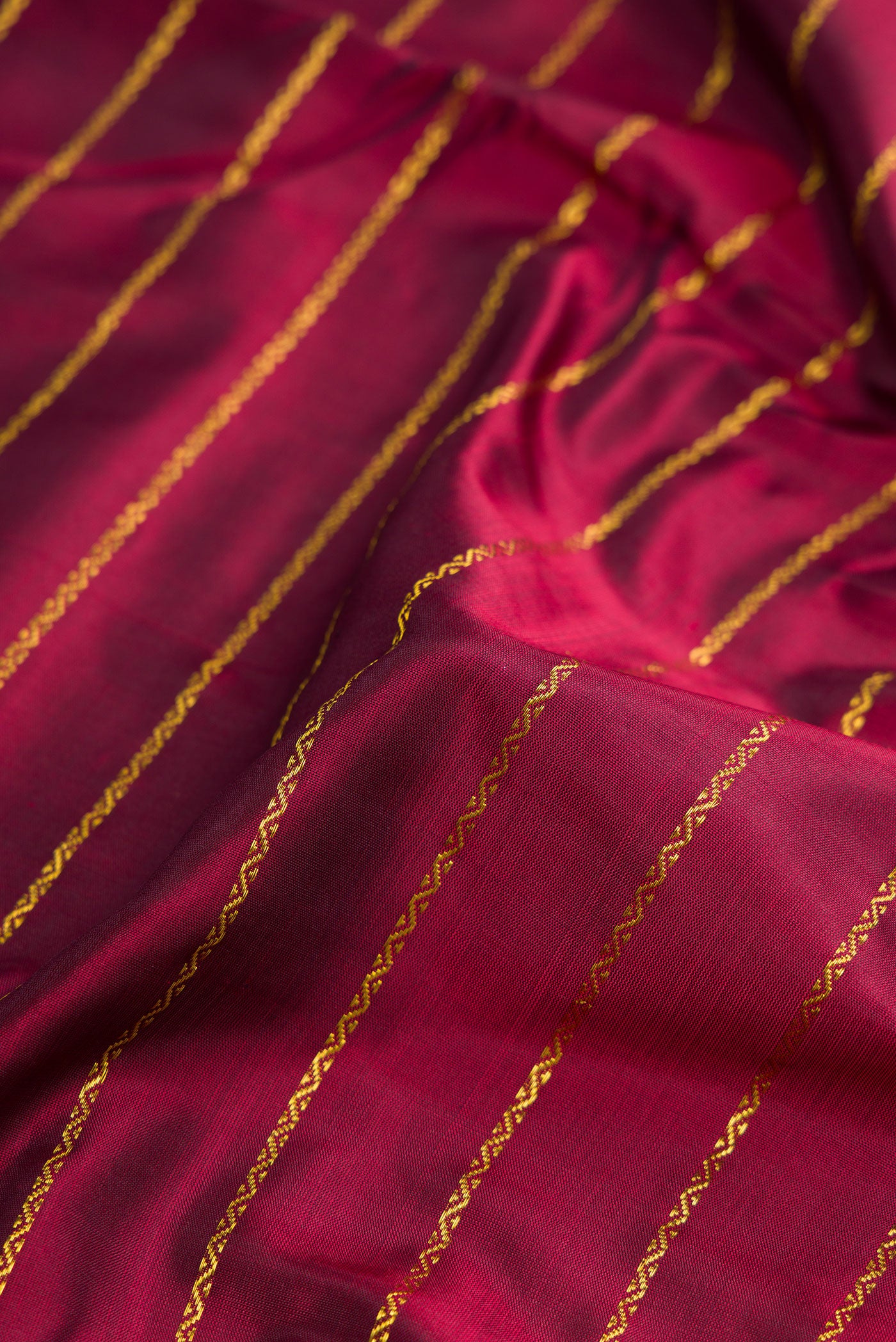 Close up of Pure Silk Pure Zari Maroon Dual Tone Kanchipuram Nine Yards Saree with Stripes on the body and Zari Border.  displaying folds