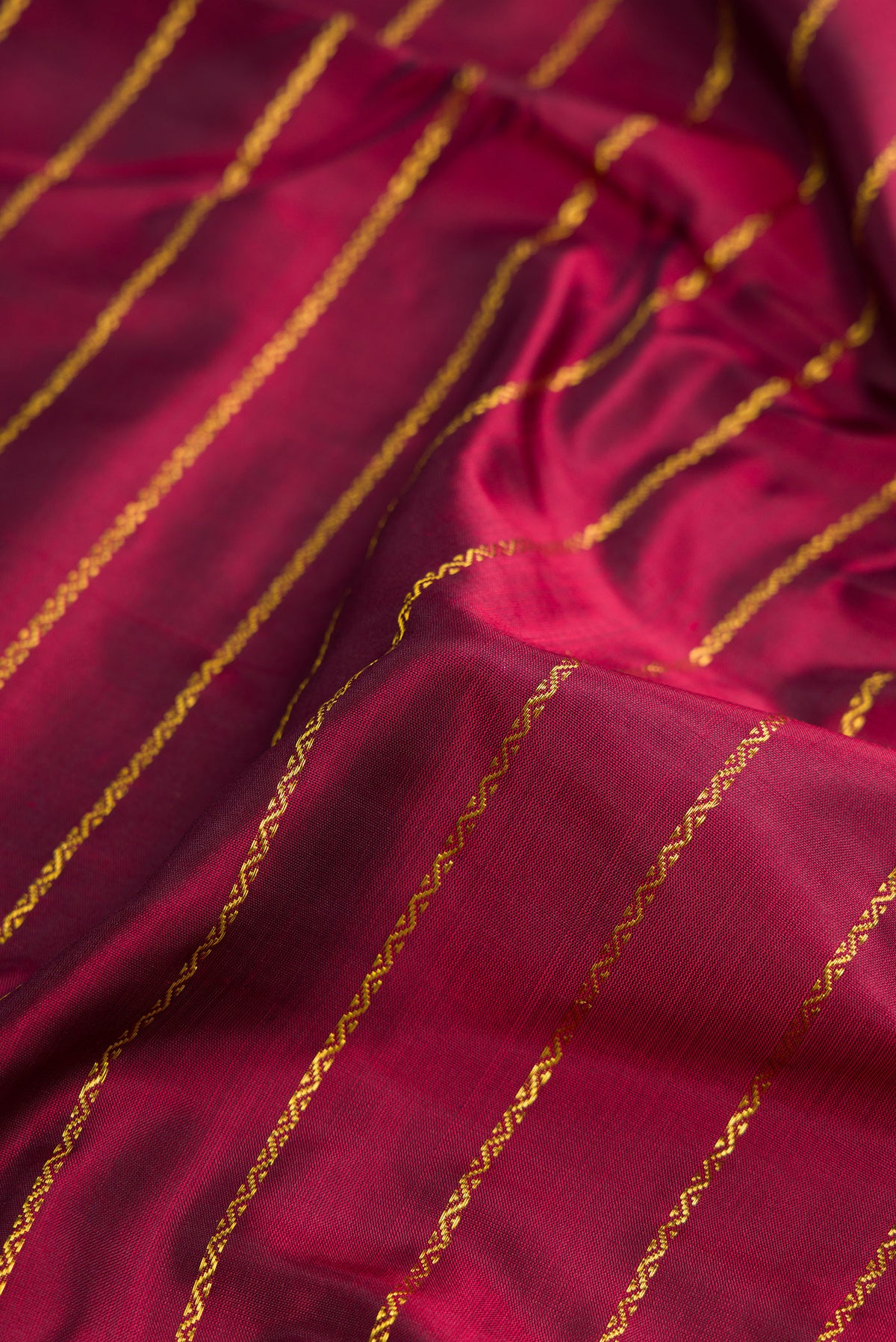 Close up of Pure Silk Pure Zari Maroon Dual Tone Kanchipuram Nine Yards Saree with Stripes on the body and Zari Border.  displaying folds