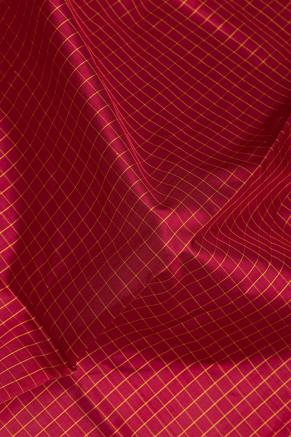 Close up of Maroon Kanjivaram Silk Saree with Checked design on the body and Zari Border.  displaying folds