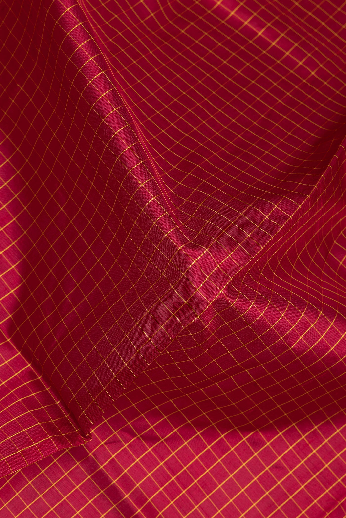 Close up of Maroon Kanjivaram Silk Saree with Checked design on the body and Zari Border.  displaying folds