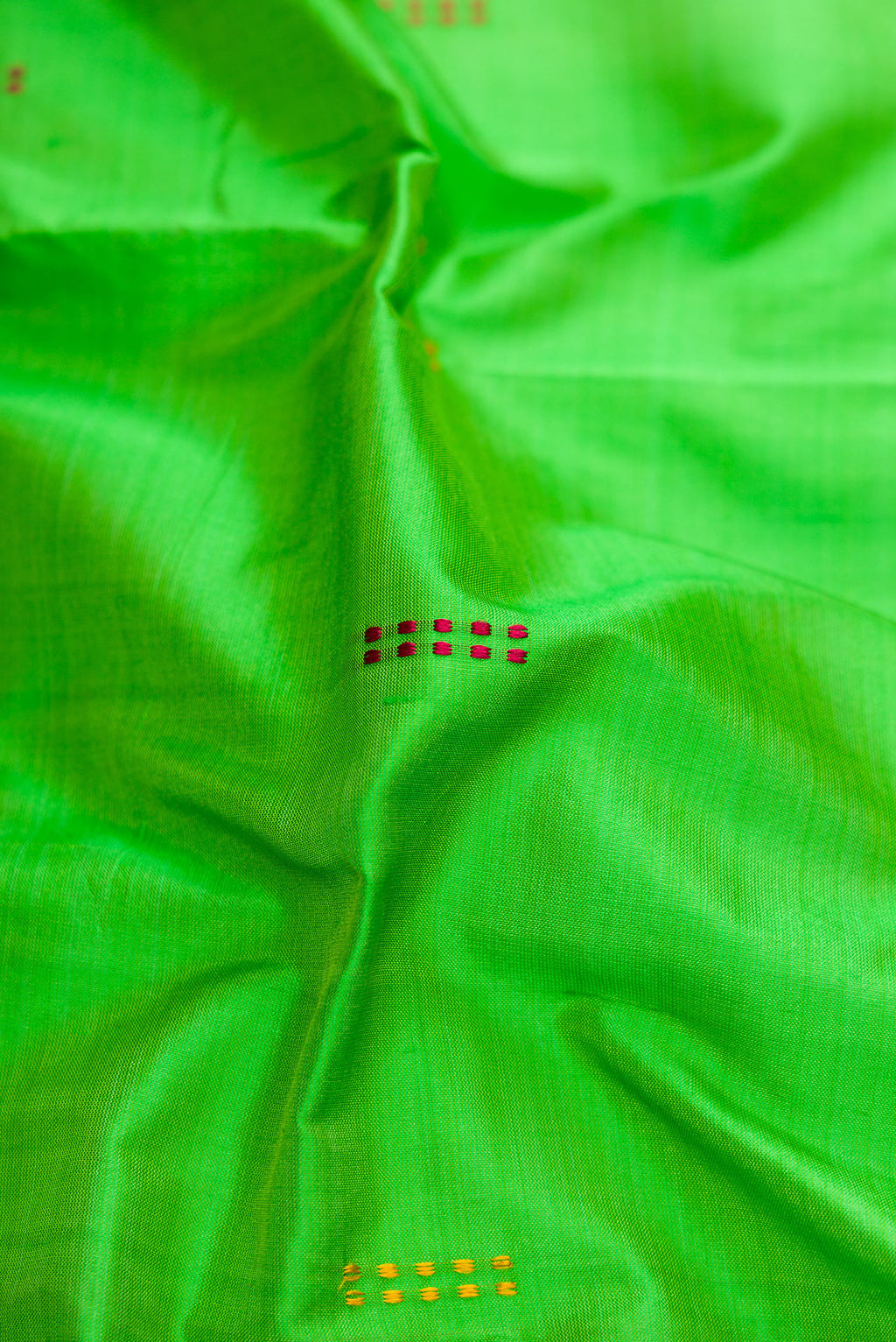 Close up of Green Dual Tone Kanchipuram Silk Saree with Thread Butta on the body and Thread Border.  displaying folds