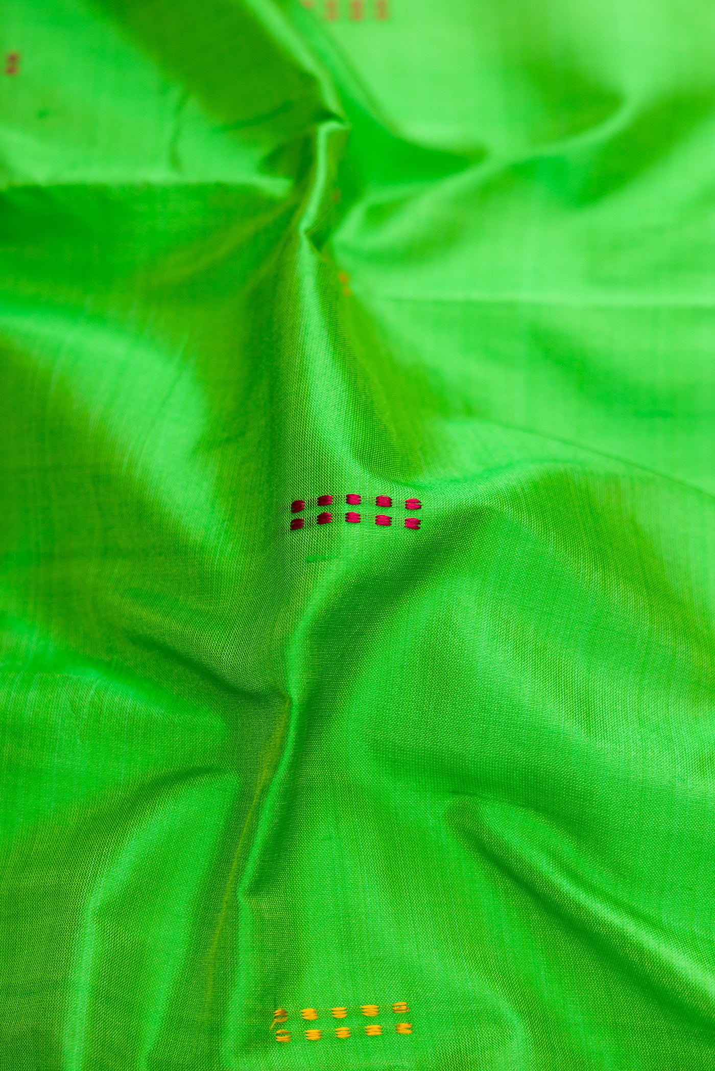 Close up of Green Dual Tone Kanchipuram Silk Saree with Thread Butta on the body and Thread Border.  displaying folds