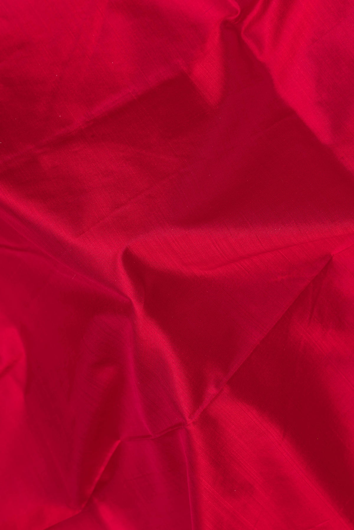 Close up of Maroon Kanchipuram Silk Saree with Plain Body and Zari Border.  displaying folds