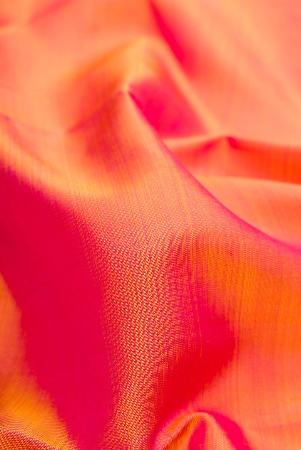 Close up of Coral Dual Tone Kanjivaram Silk Saree with Plain Body and Zari Border.  displaying folds