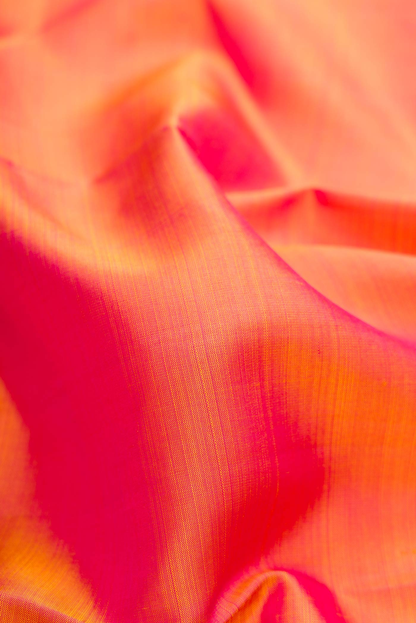 Close up of Coral Dual Tone Kanjivaram Silk Saree with Plain Body and Zari Border.  displaying folds