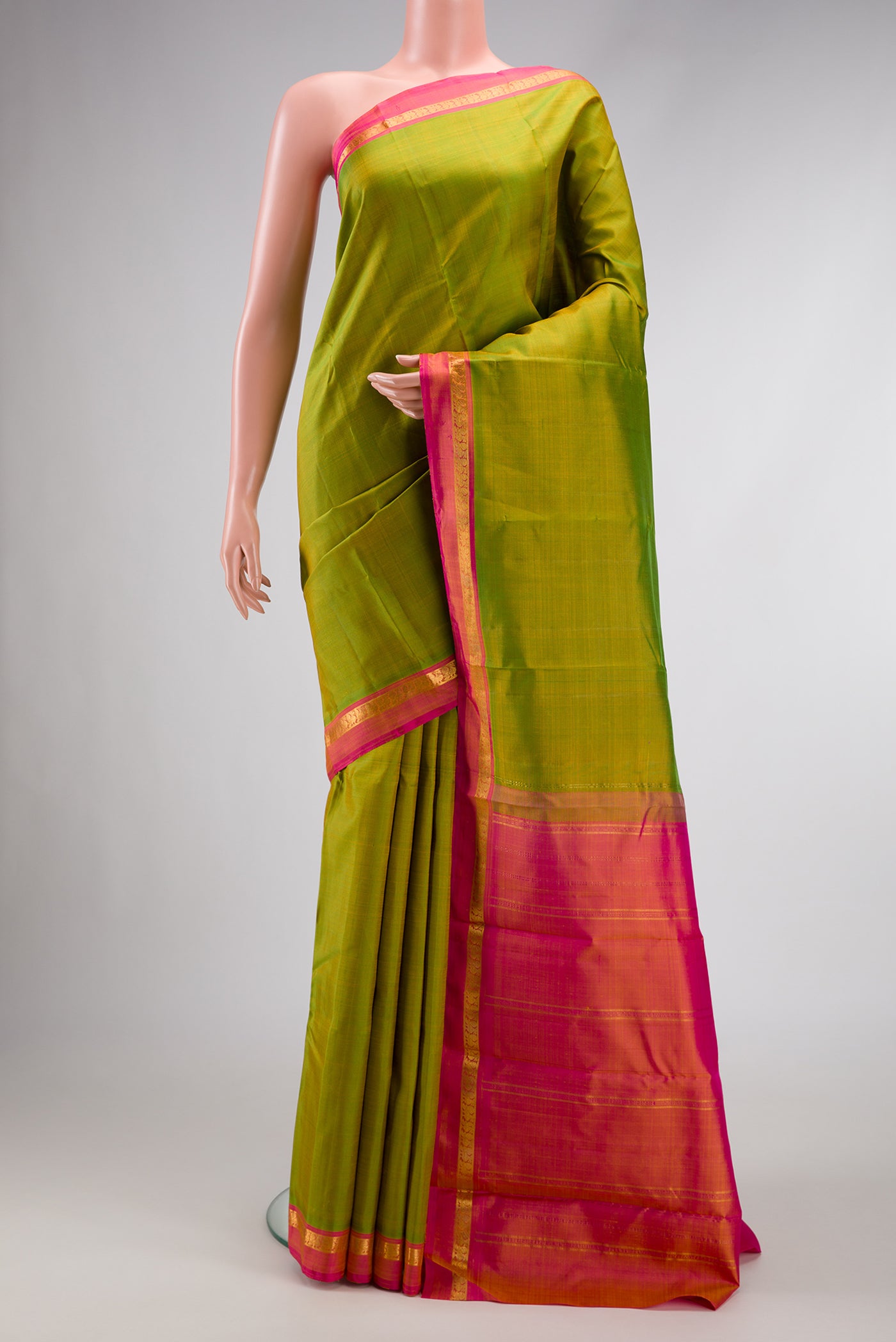 Parrot Green Dual Tone Kanchipuram Silk Saree with Plain Body and Zari Border.  displayed on a mannequin