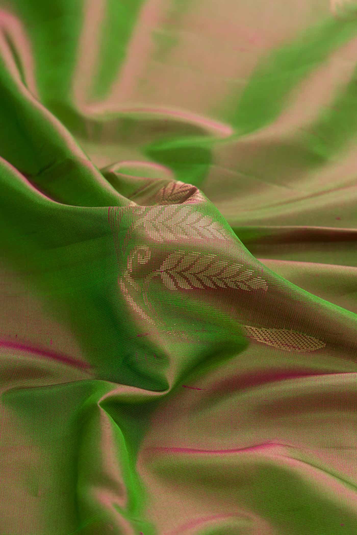 Close up of Green Dual Tone Soft Silk Saree with Zari Butta on the body and Zari Border displaying folds