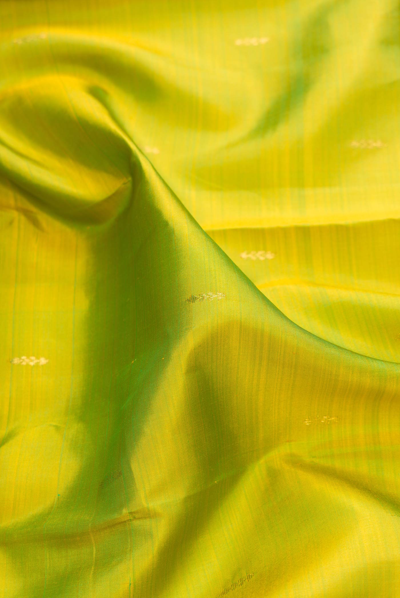 Close up of Parrot Green Dual Tone Kanchipuram Silk Saree with Zari Butta on the body and Zari Border.  displaying folds