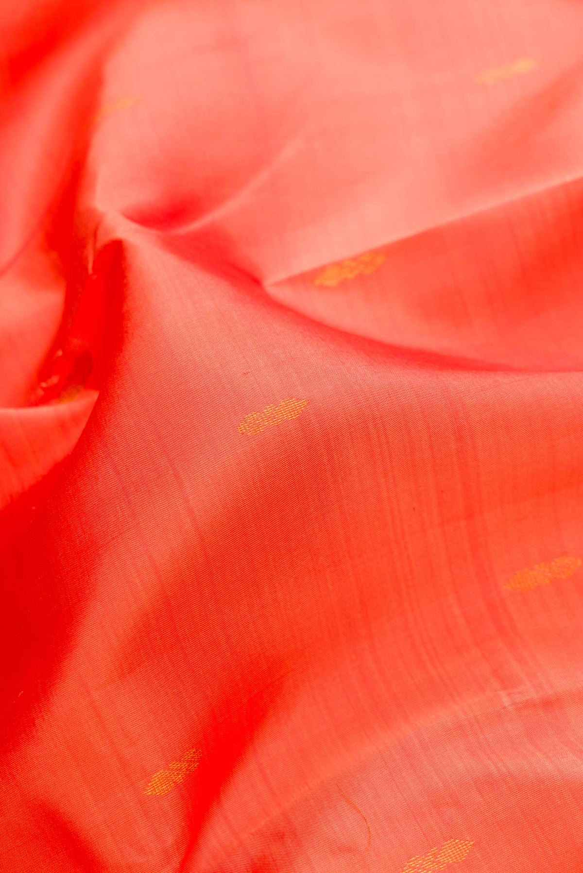 Close up of Peach Dual Tone Kanchipuram Silk Saree with Zari Butta on the body and Zari Border.  displaying folds