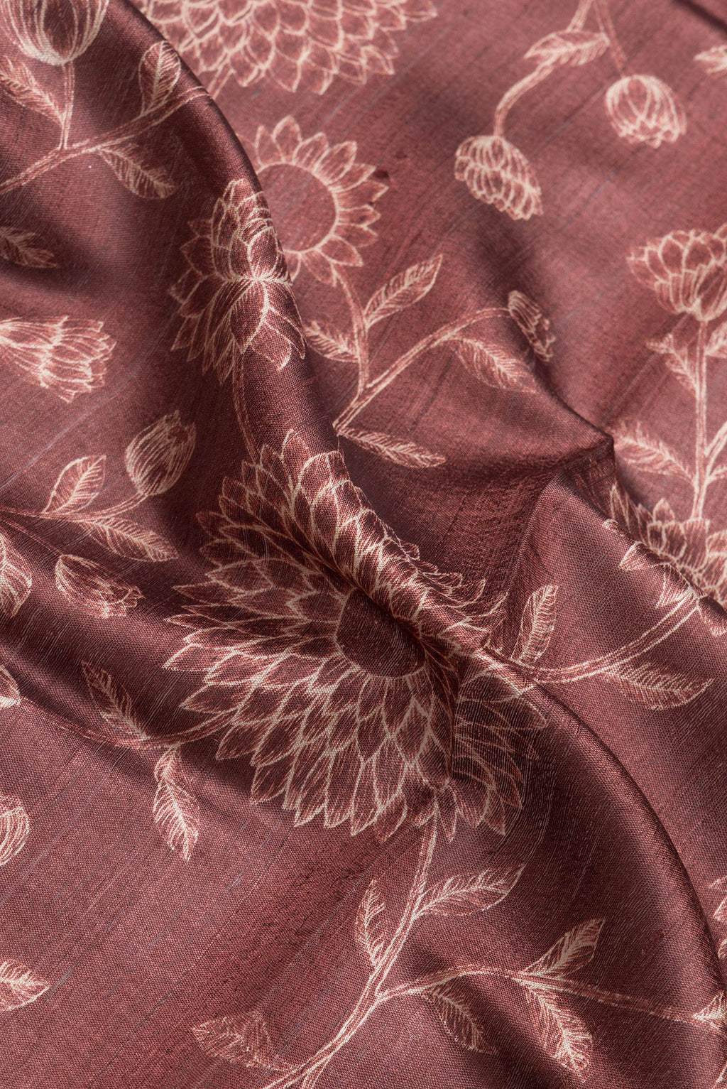 Close up of Maroon Dual Tone Tussar Silk Saree with Printed design on the body and Zari Border.  displaying folds