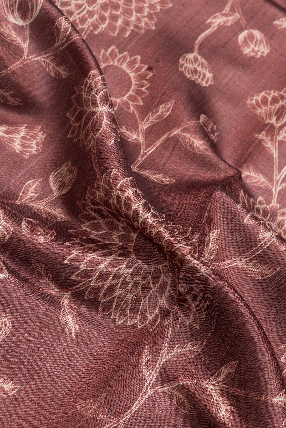 Close up of Maroon Dual Tone Tussar Silk Saree with Printed design on the body and Zari Border.  displaying folds