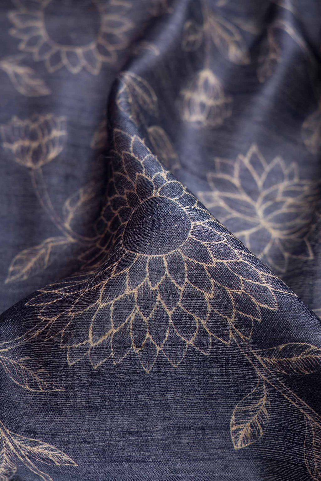 Close up of Navy Blue Dual Tone Tussar Silk Saree with Printed design on the body and Zari Border.  displaying folds