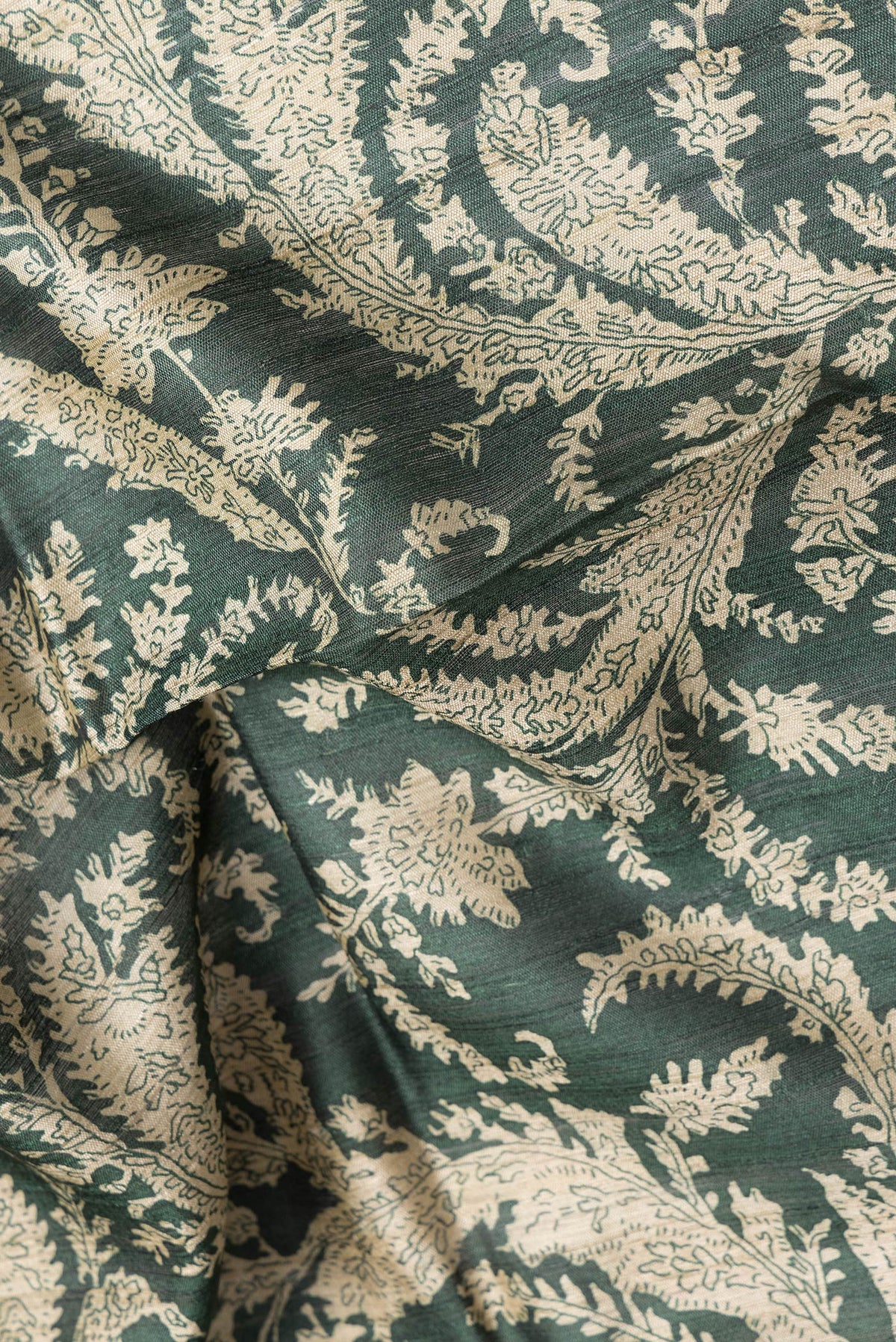 Close up of Bottle Green Dual Tone Tussar Silk Saree with Printed design on the body and Embroidery Border.  displaying folds