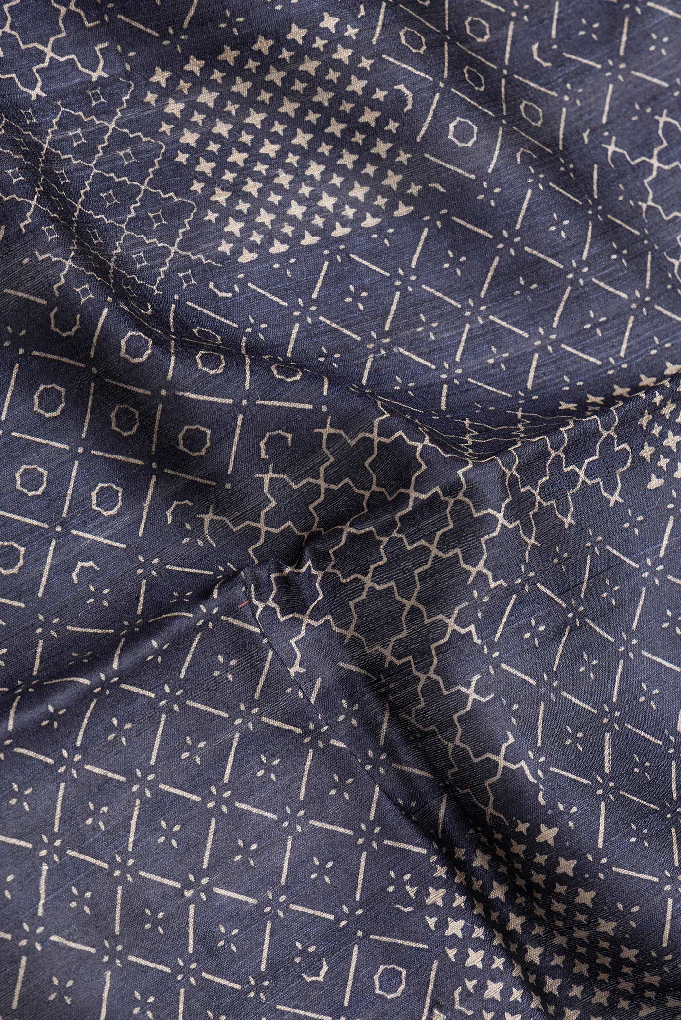 Close up of Navy Blue Dual Tone Tussar Silk Saree with Printed design on the body and Embroidery Border.  displaying folds