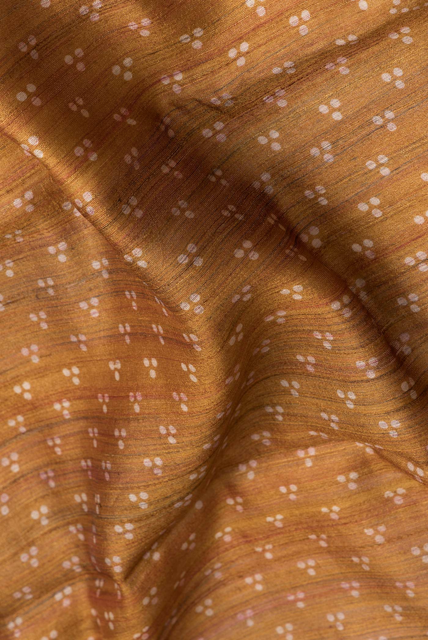 Close up of Mustard Dual Tone Tussar Silk Saree with Printed design on the body and Embroidery Border.  displaying folds