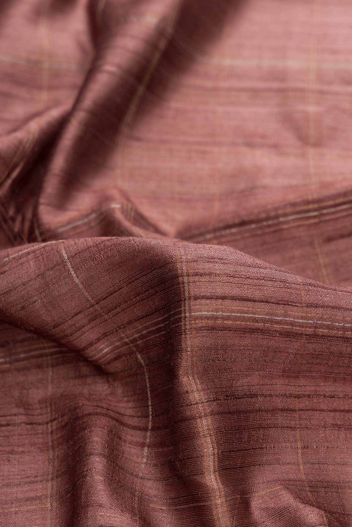 Close up of Bronze Dual Tone Tussar Silk Saree with Checked design on the body and Zari Border displaying folds