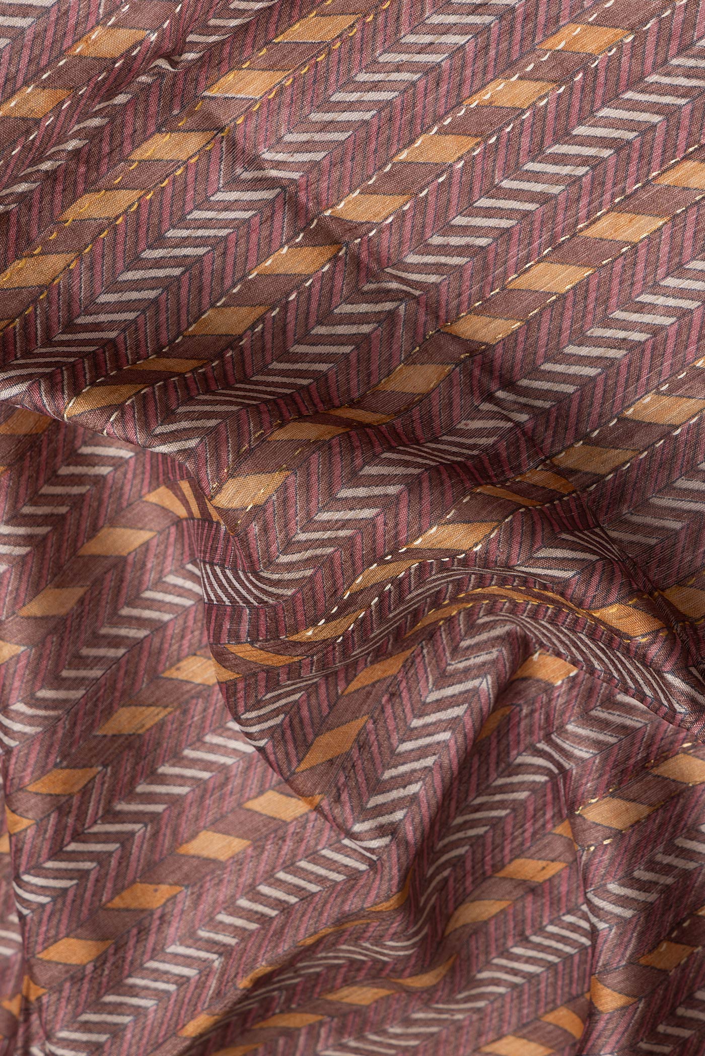 Close up of Brown Dual Tone Tussar Silk Saree with Embroidery on the body and Embroidery Border.  displaying folds