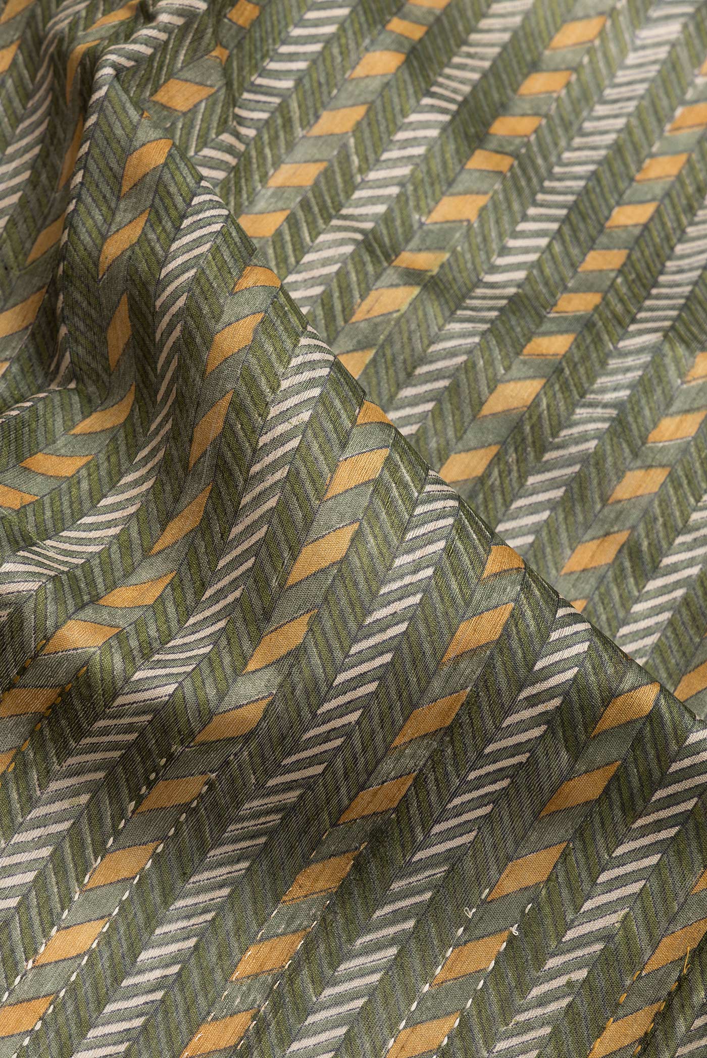 Close up of Mehandi Green Dual Tone Tussar Silk Saree with Printed design on the body and Zari Border.  displaying folds