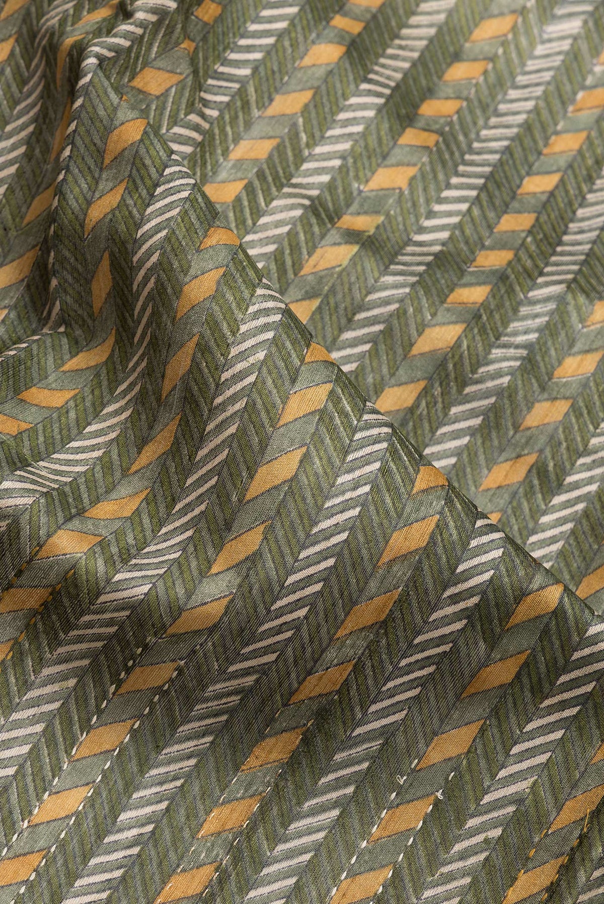 Close up of Mehandi Green Dual Tone Tussar Silk Saree with Printed design on the body and Zari Border.  displaying folds