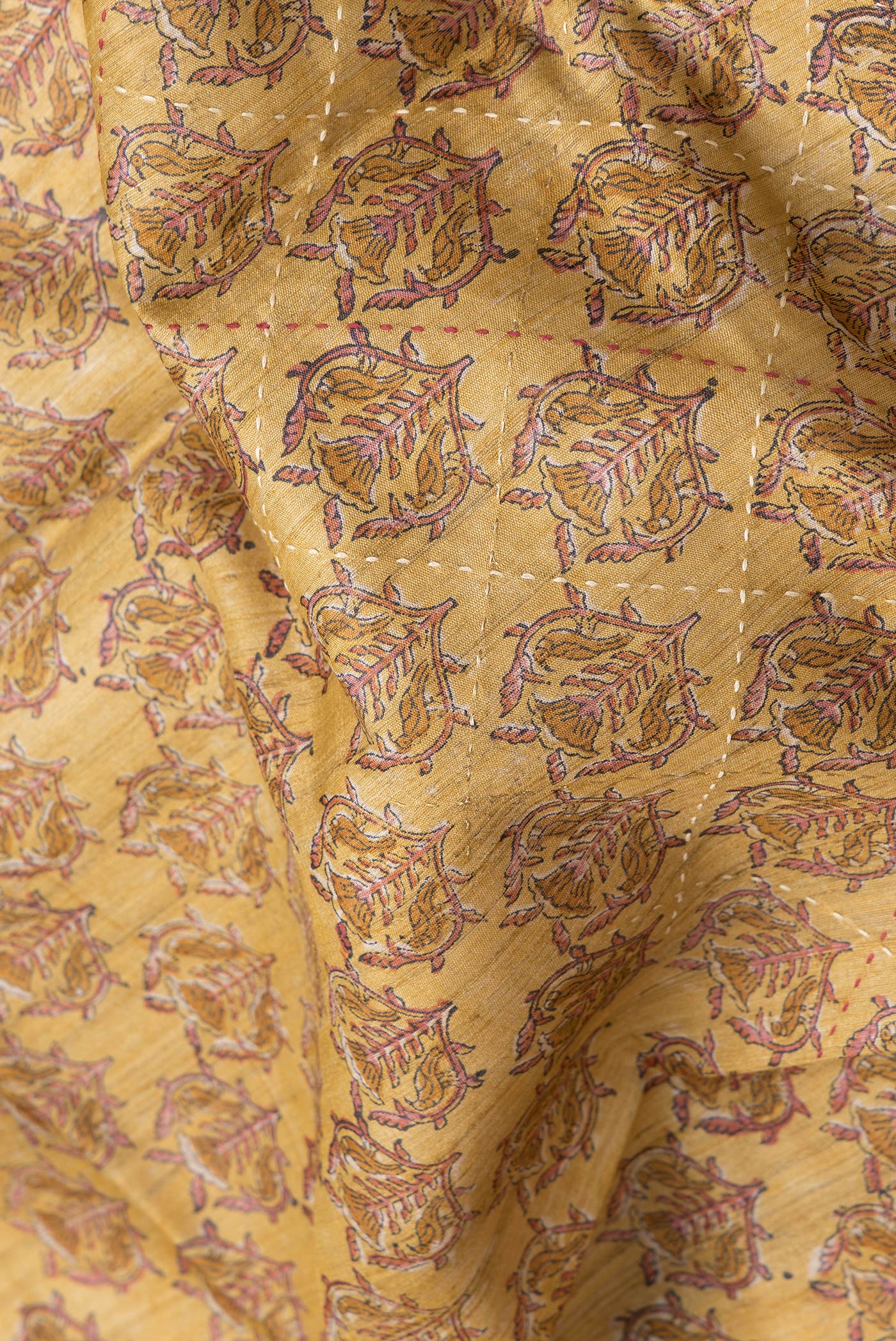 Close up of Mustard Dual Tone Tussar Silk Saree with Printed design on the body and Zari And Thread Border.  displaying folds