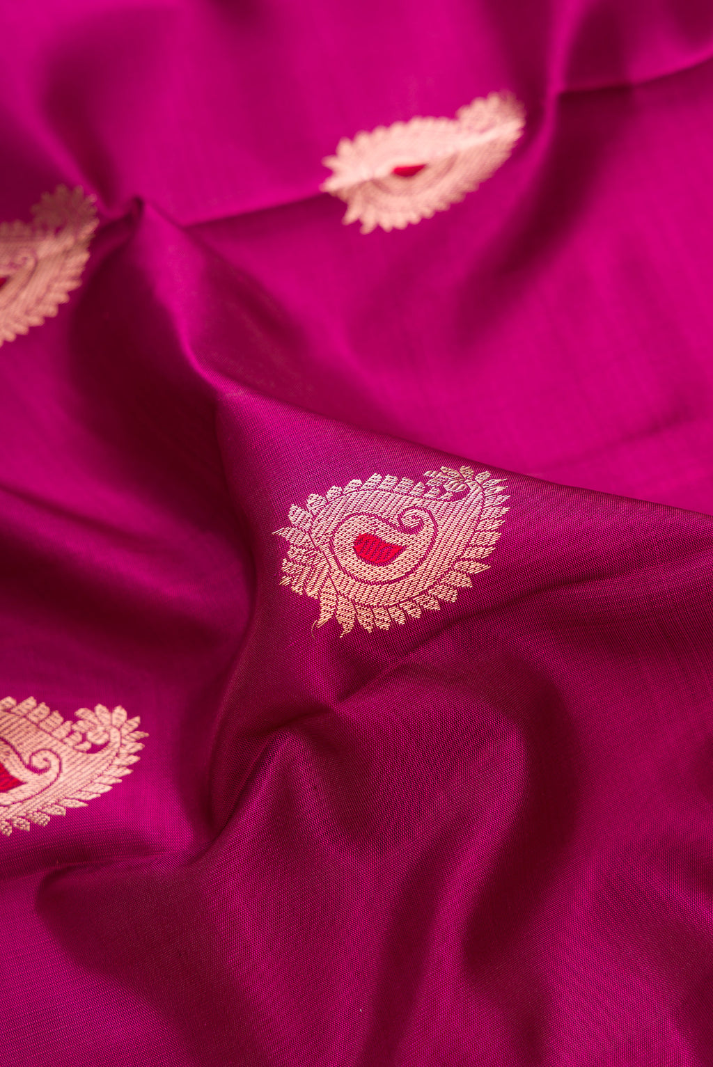 Close up of Maroon Dual Tone Kanjivaram Silk Saree with Zari And Thread Butta on the body and Zari Border.  displaying folds