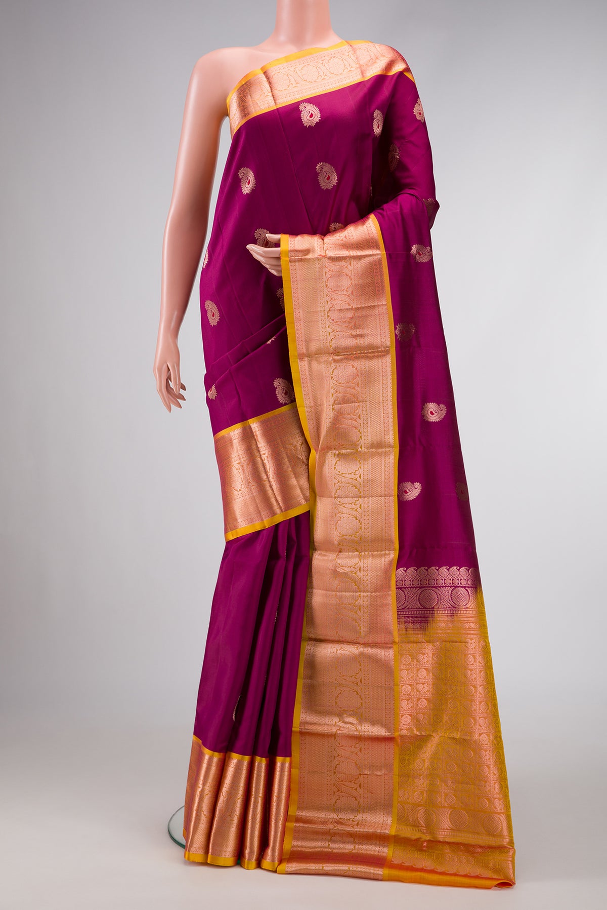 Maroon Dual Tone Kanjivaram Silk Saree with Zari And Thread Butta on the body and Zari Border.  displayed on a mannequin