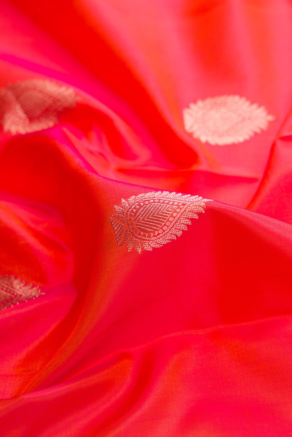 Close up of Orange Dual Tone Kanjivaram Silk Saree with Zari Butta on the body and Zari Border.  displaying folds