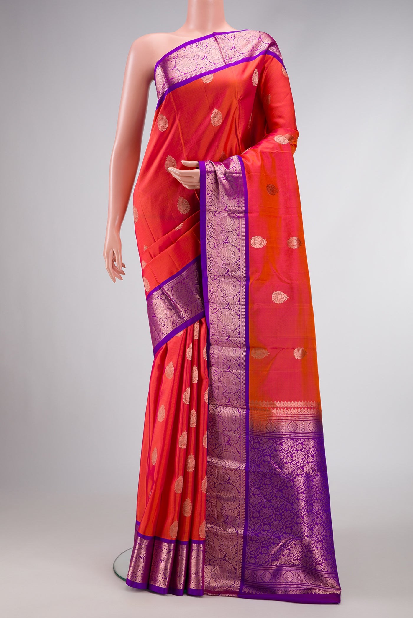 Orange Dual Tone Kanjivaram Silk Saree with Zari Butta on the body and Zari Border.  displayed on a mannequin