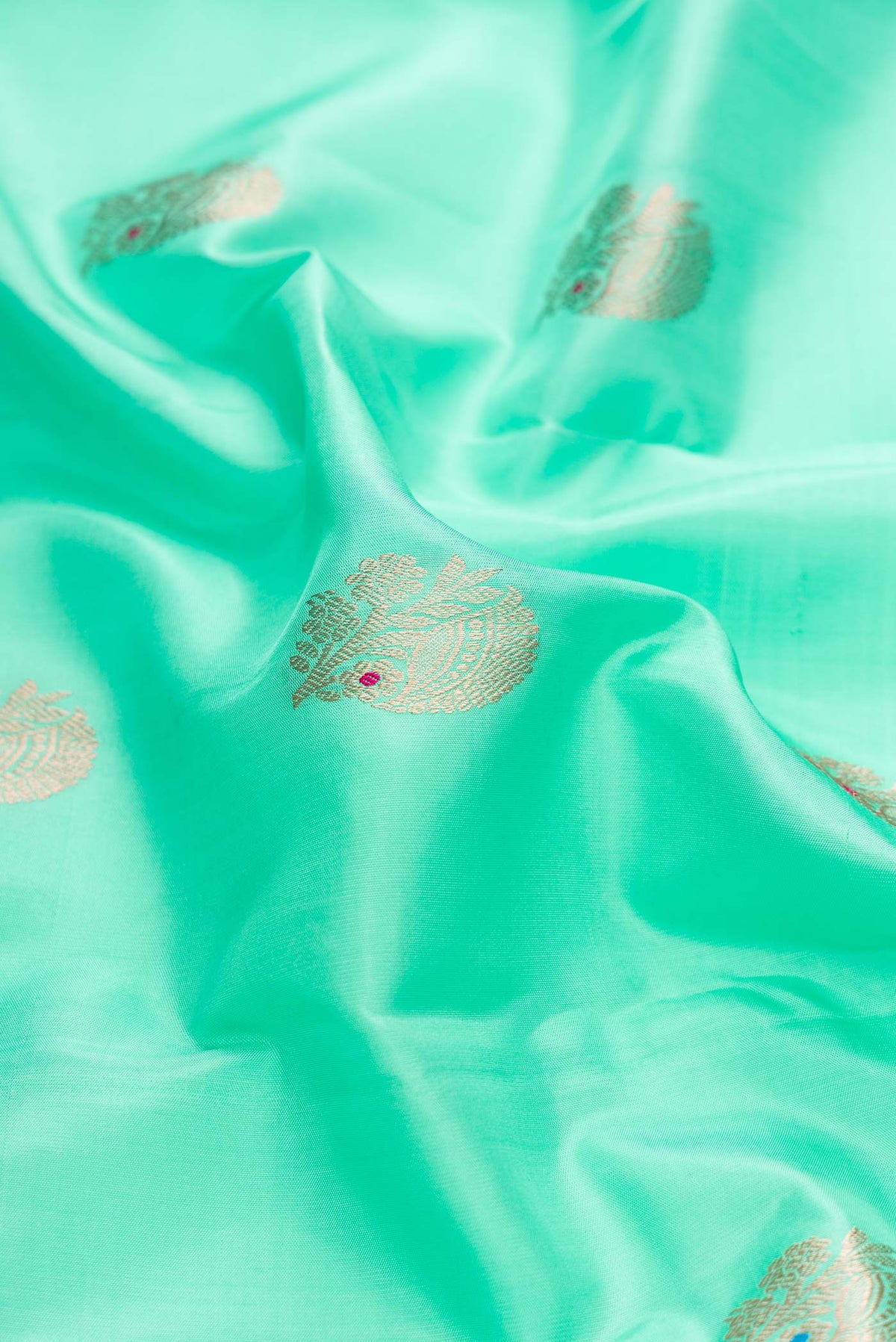Close up of Light Green Dual Tone Kanchipuram Silk Saree with Zari Butta on the body and Zari Border displaying folds