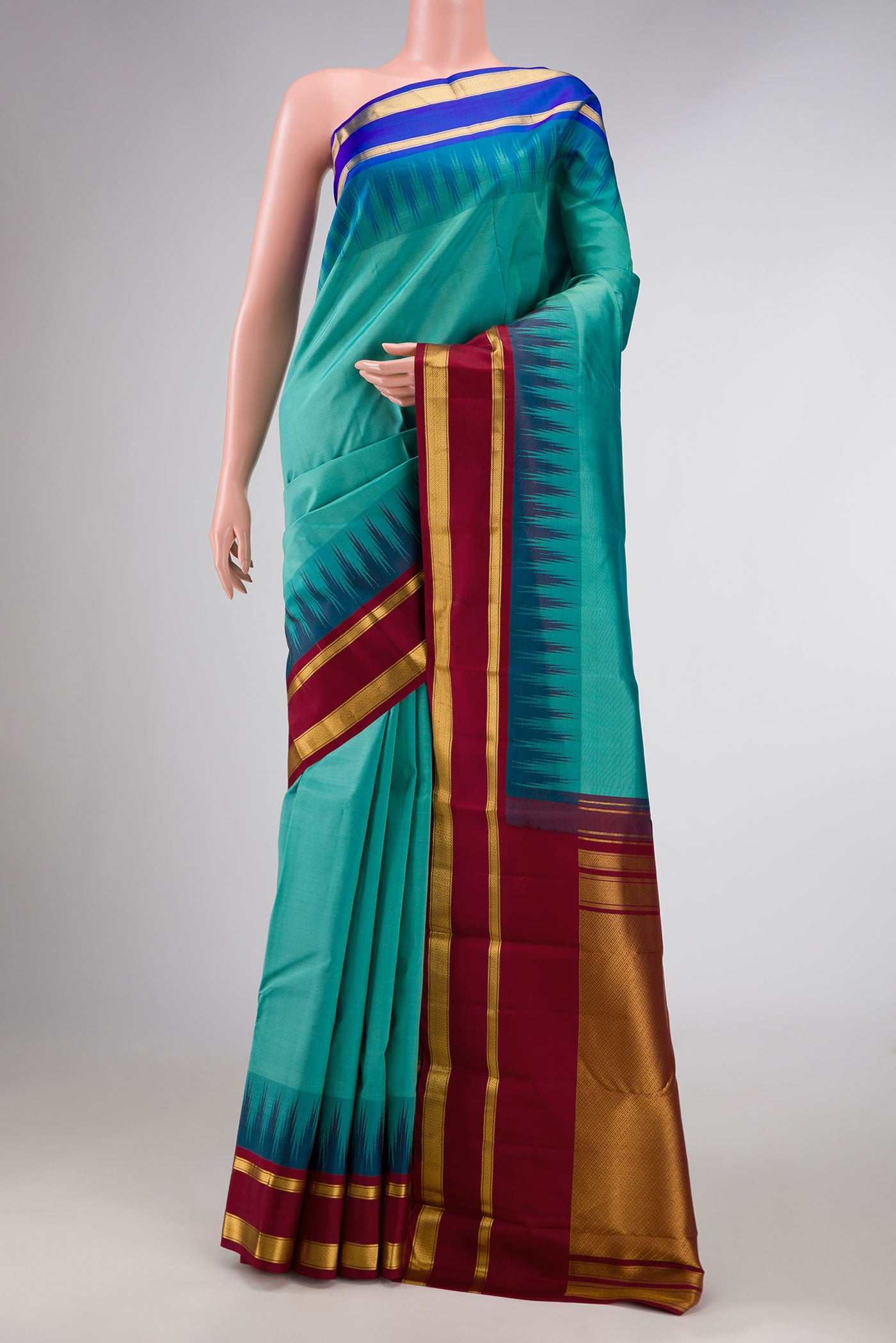 Green Dual Tone Kanchipuram Silk Saree with Zari Butta on the body and Ganga Jamuna Border displayed on a mannequin