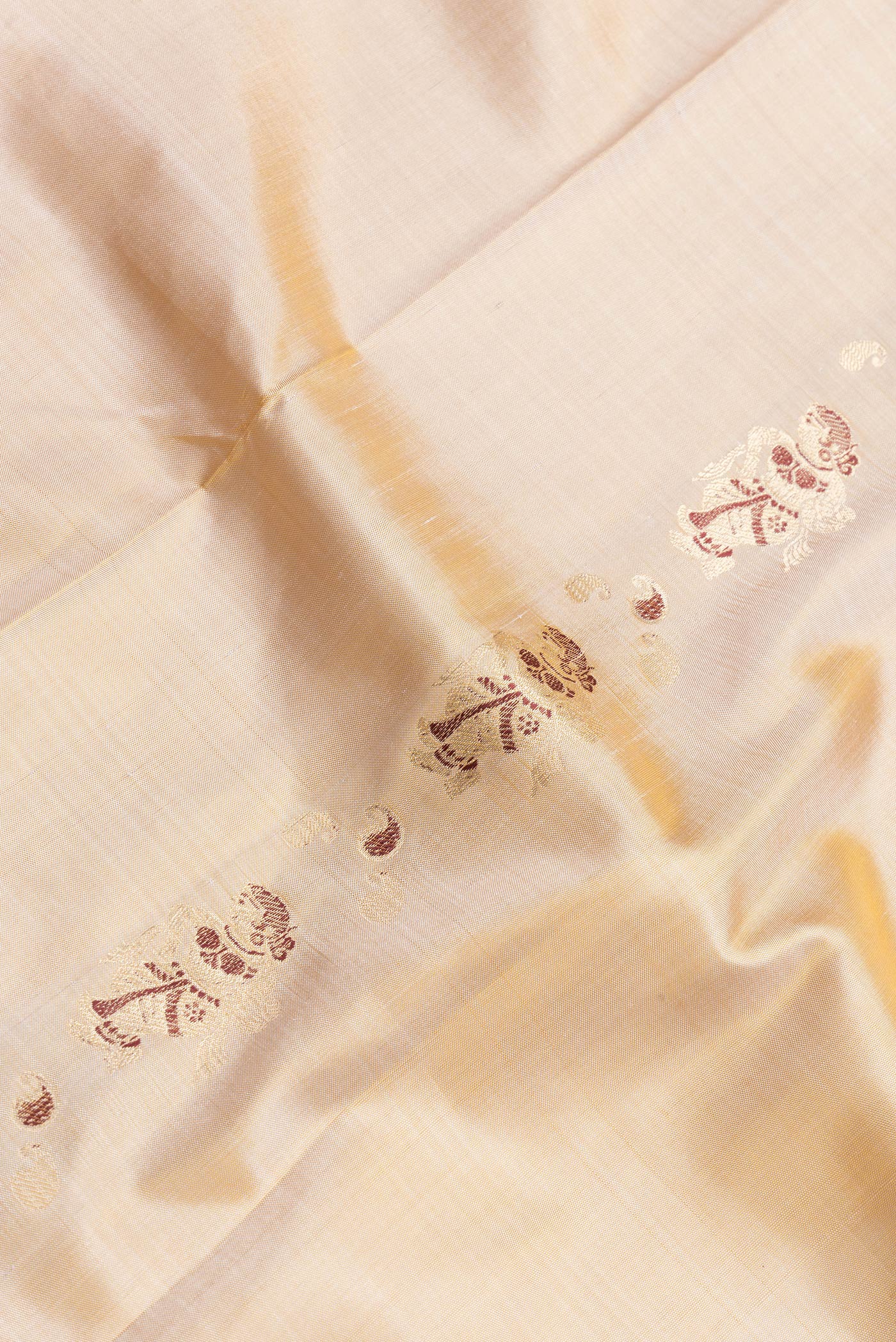 Close up of Beige Dual Tone Baluchari Silk Saree with Zari And Thread Butta on the body and Fancy Border.  displaying folds
