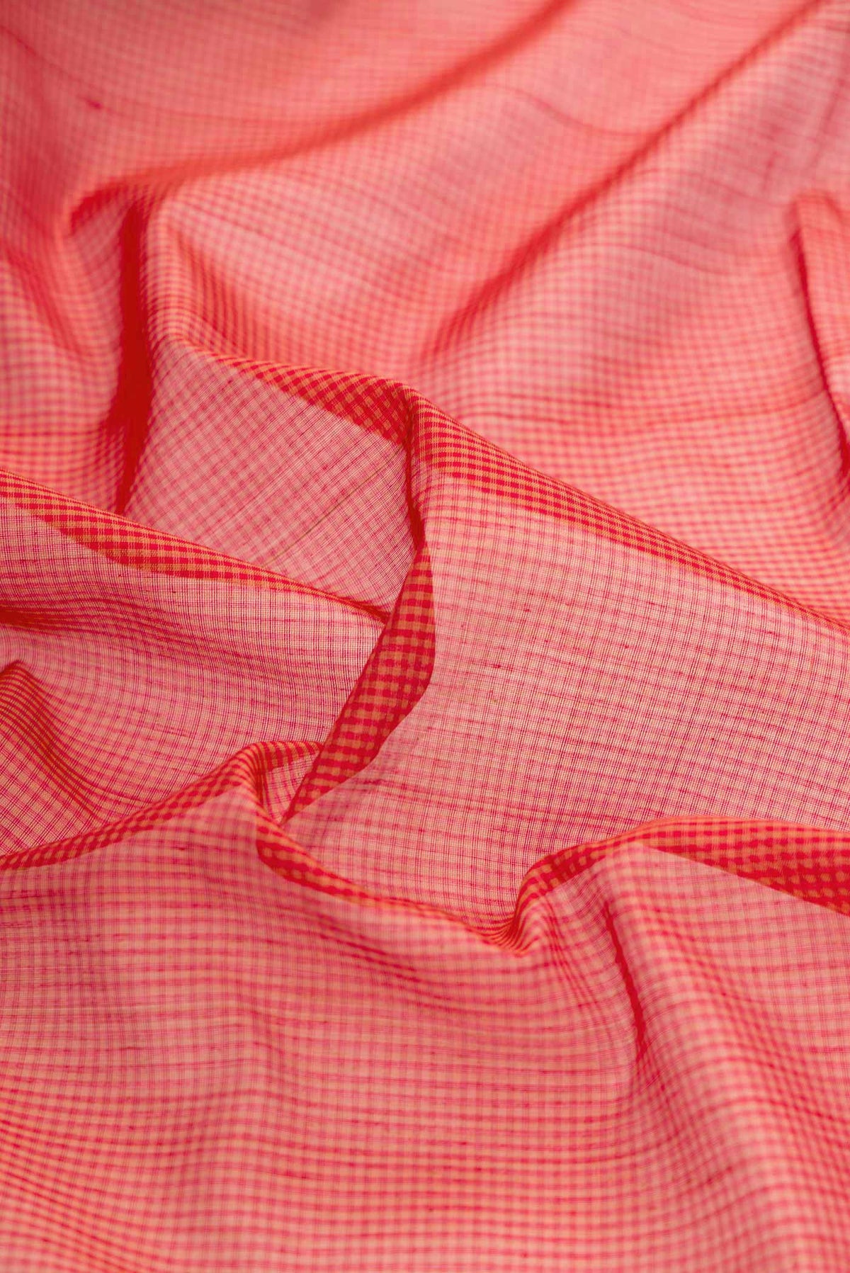 Close up of Red Dual Tone Silk Cotton Saree with Checked design on the body and Zari Border displaying folds