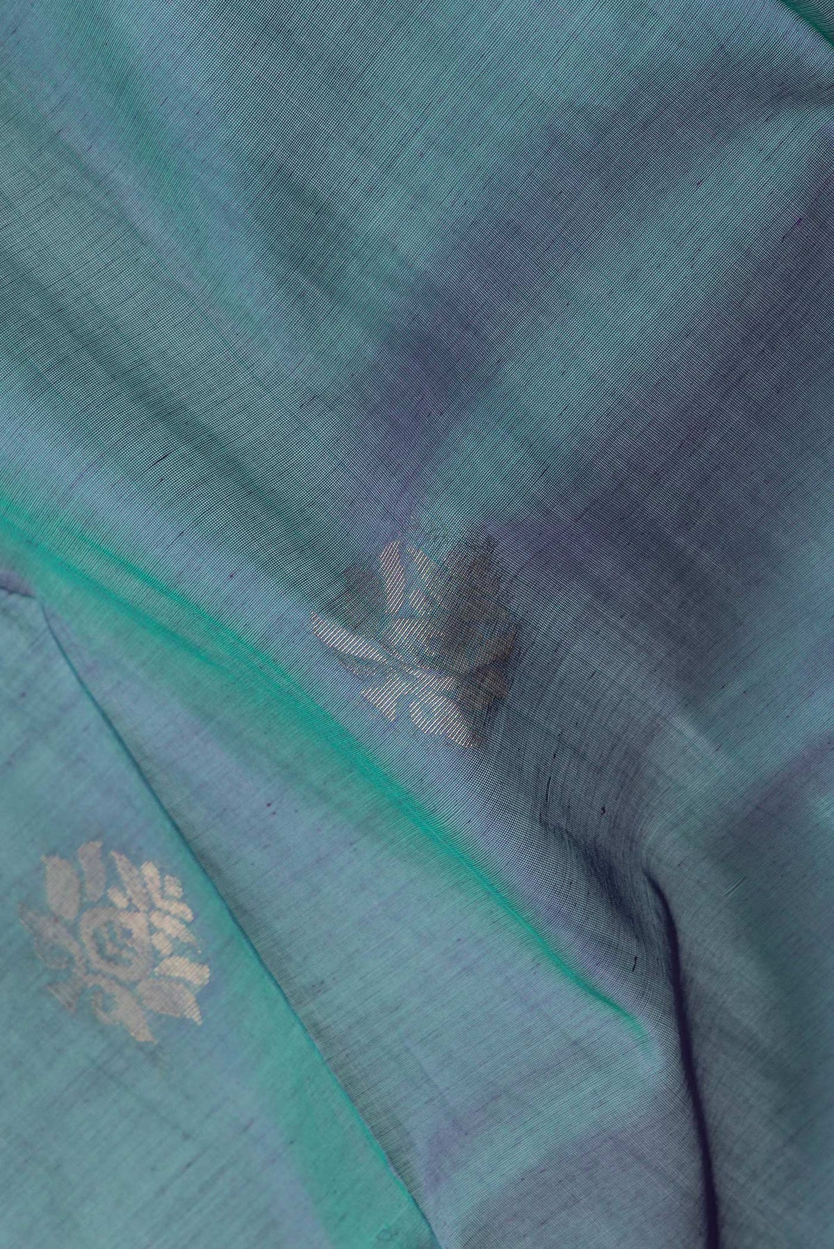 Close up of Peacock Blue Dual Tone Silk Cotton Saree with Zari Butta on the body and Zari Border.  displaying folds