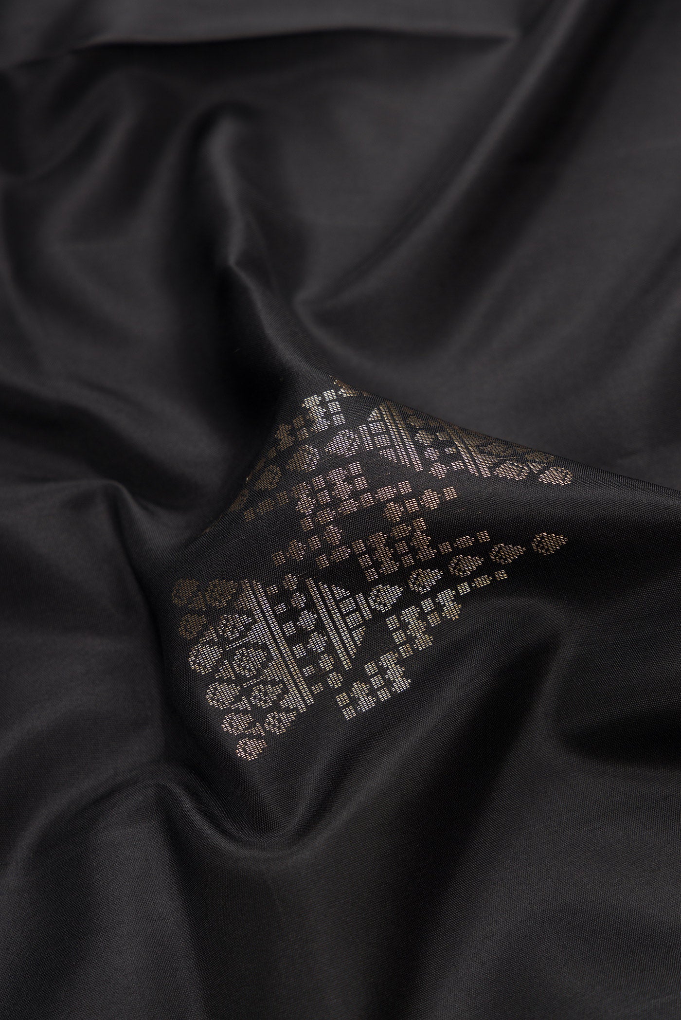 Close up of Black Dual Tone Soft Silk Saree with Zari Butta on the body and Zari Border.  displaying folds
