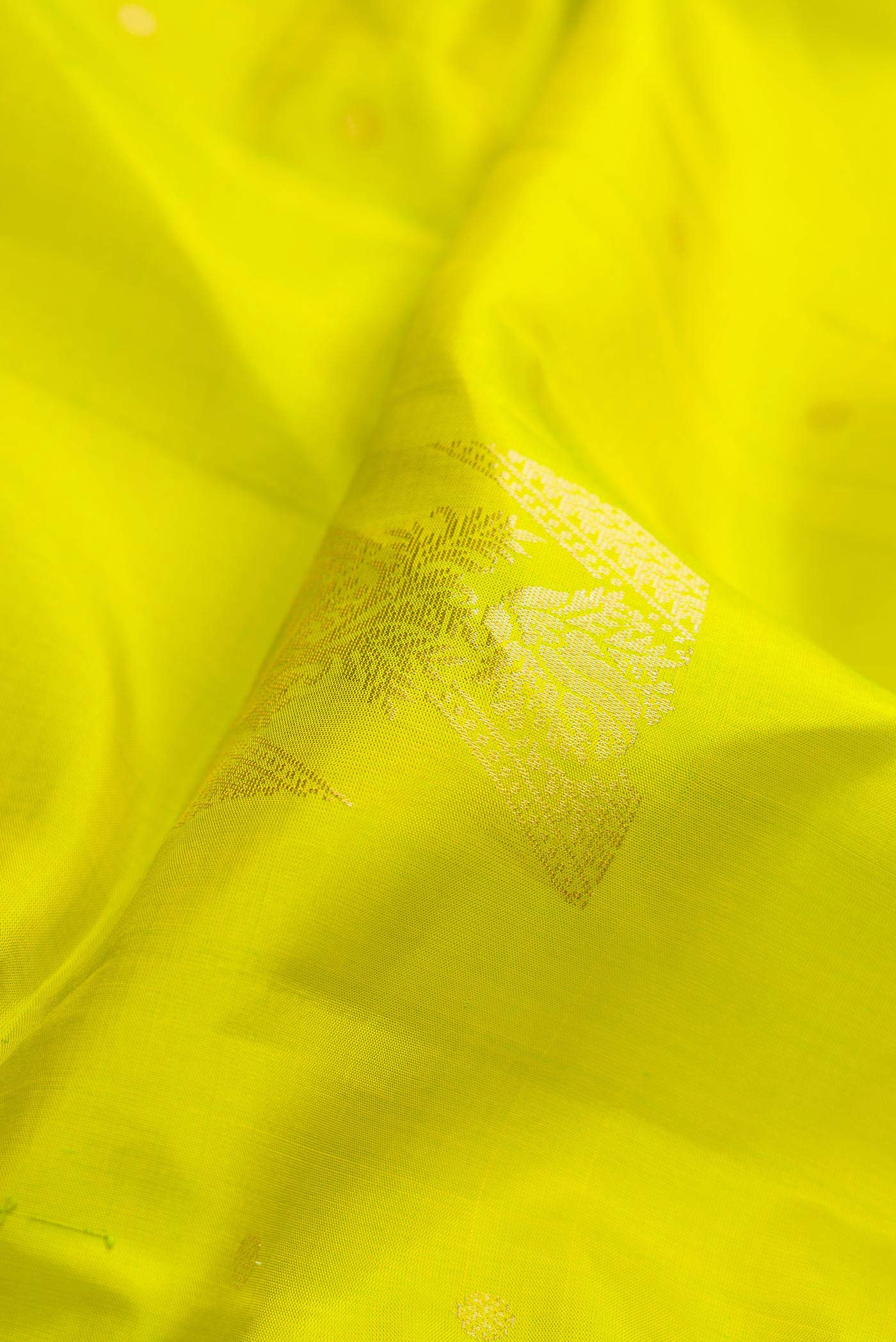 Close up of Parrot Green Dual Tone Soft Silk Saree with Zari Butta on the body and Zari Border displaying folds