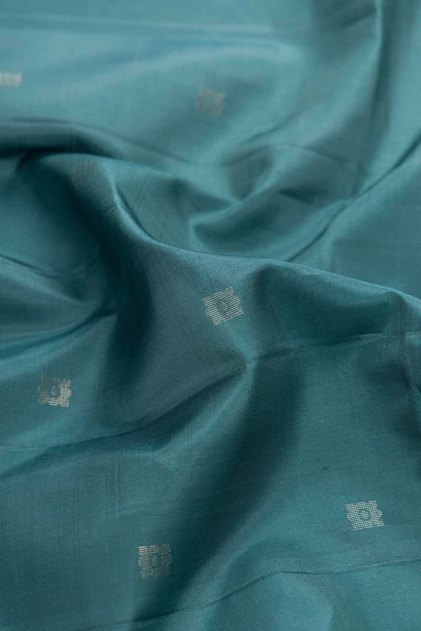Close up of Maya Blue Dual Tone Soft Silk Saree with Zari Butta on the body and Without Border displaying folds