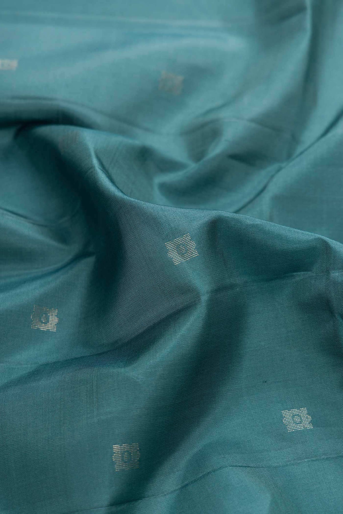 Close up of Maya Blue Dual Tone Soft Silk Saree with Zari Butta on the body and Without Border displaying folds