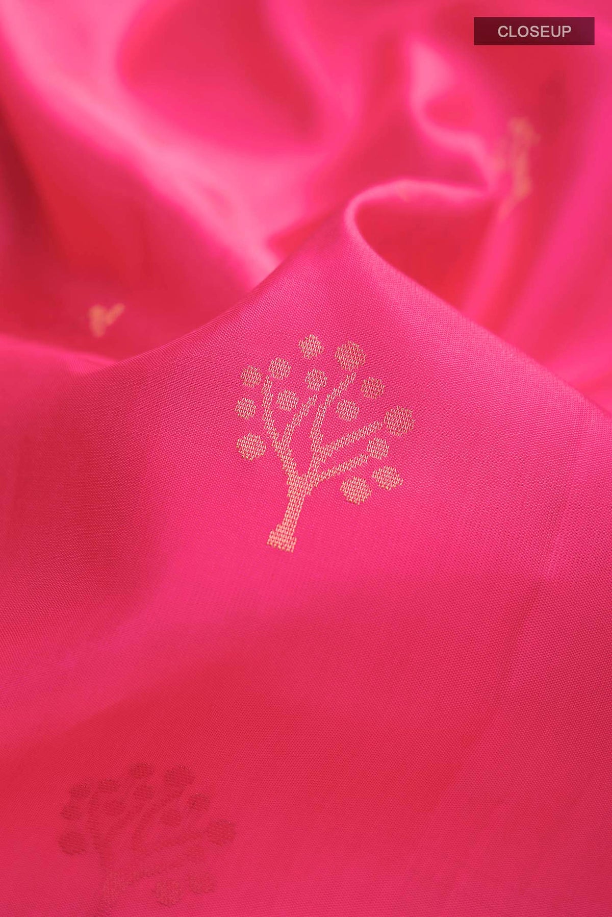 Close up of Pink Soft Silk Saree with Zari Butta on the body and Zari Border displaying folds